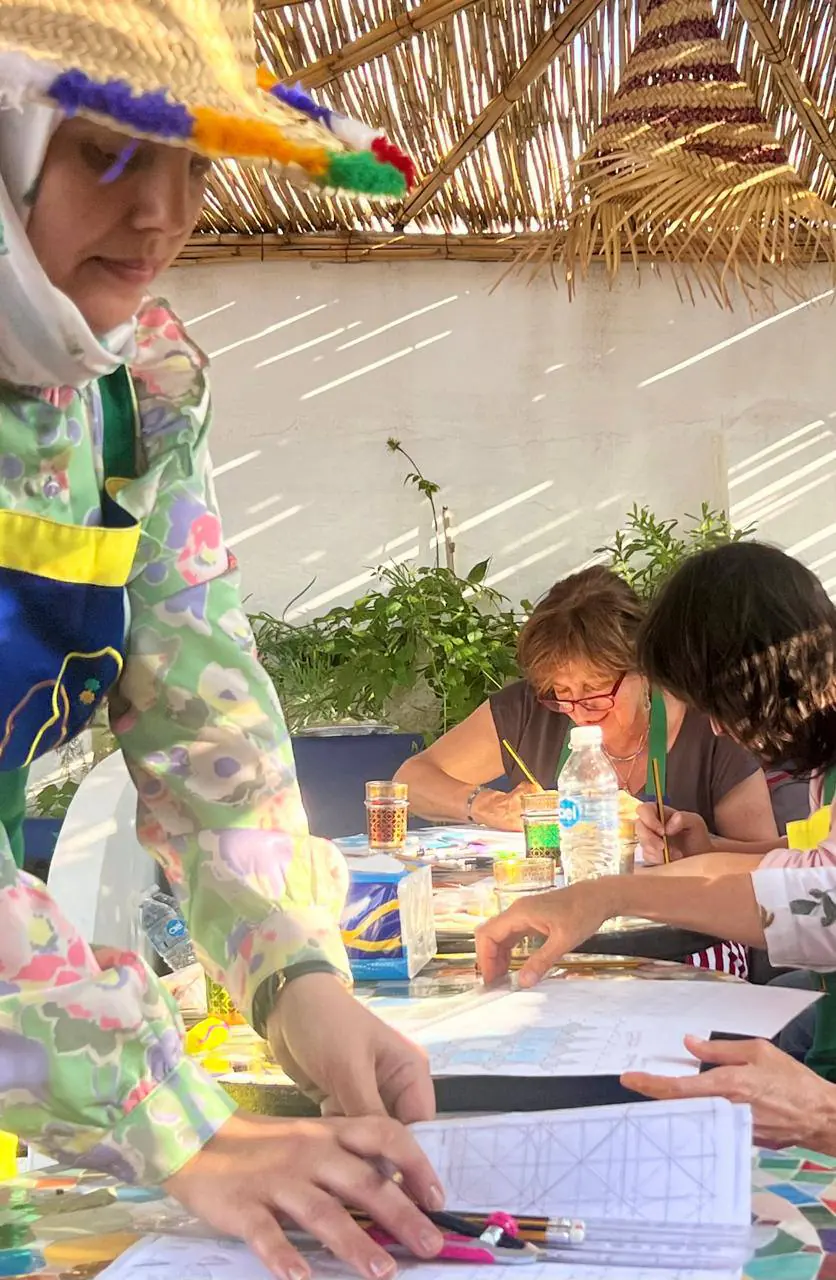 Guests painting zellige during a workshop on the rooftop